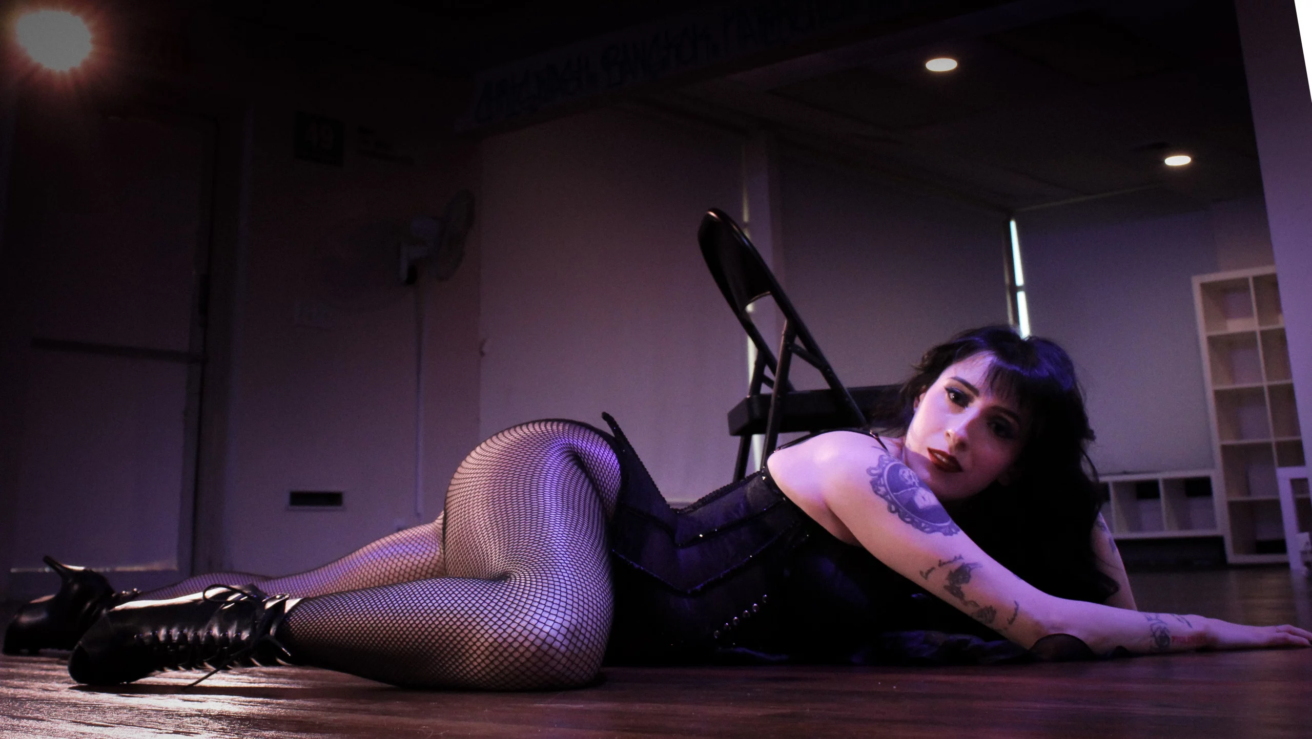 Woman in lingerie laying on the ground.