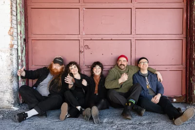 The band chilling against a garage door.