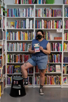 Bookstores owners pose with the book they reviewed
