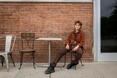 Elijah June sits at a table outside the coffee shop