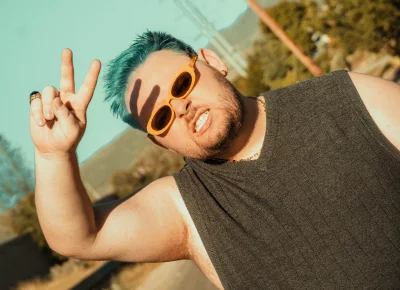 A man in sunglasses giving a peace sign.