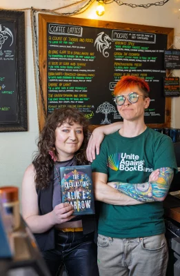 Bookstores owners pose with the book they reviewed