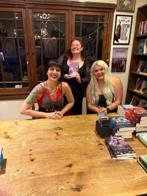 Bookstores owners pose with the book they reviewed